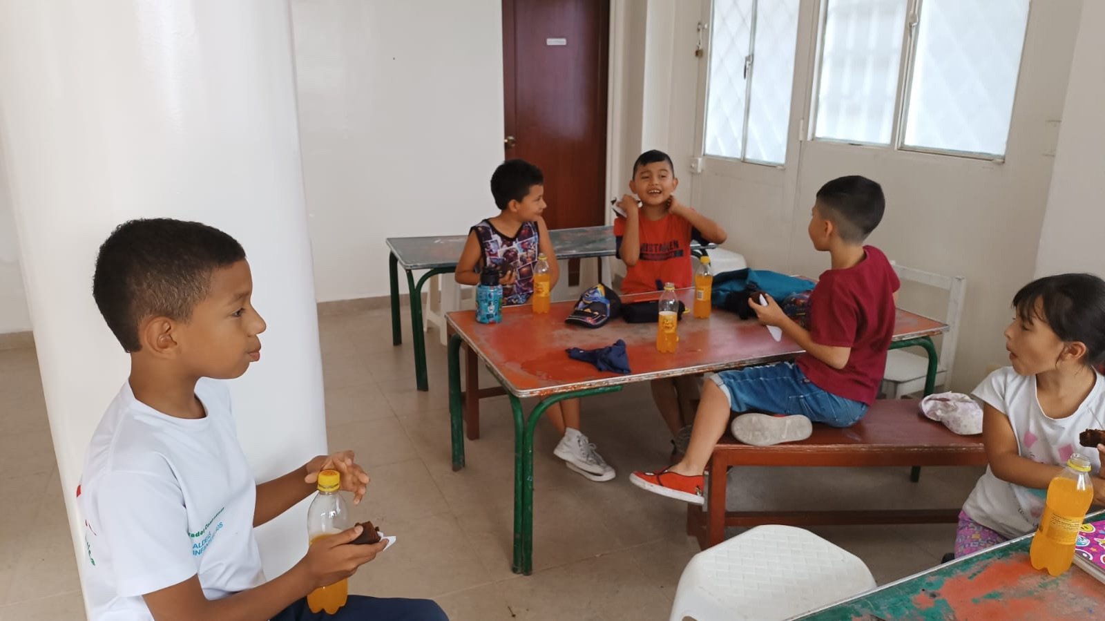 Niños compartiendo su refrigerio en una mesa